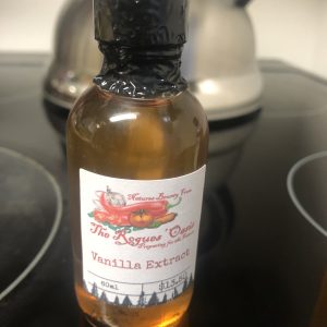 Crafted vanilla extract bottle with artisanal label by The Rogues' Oasis, emphasizing flavor and quality.