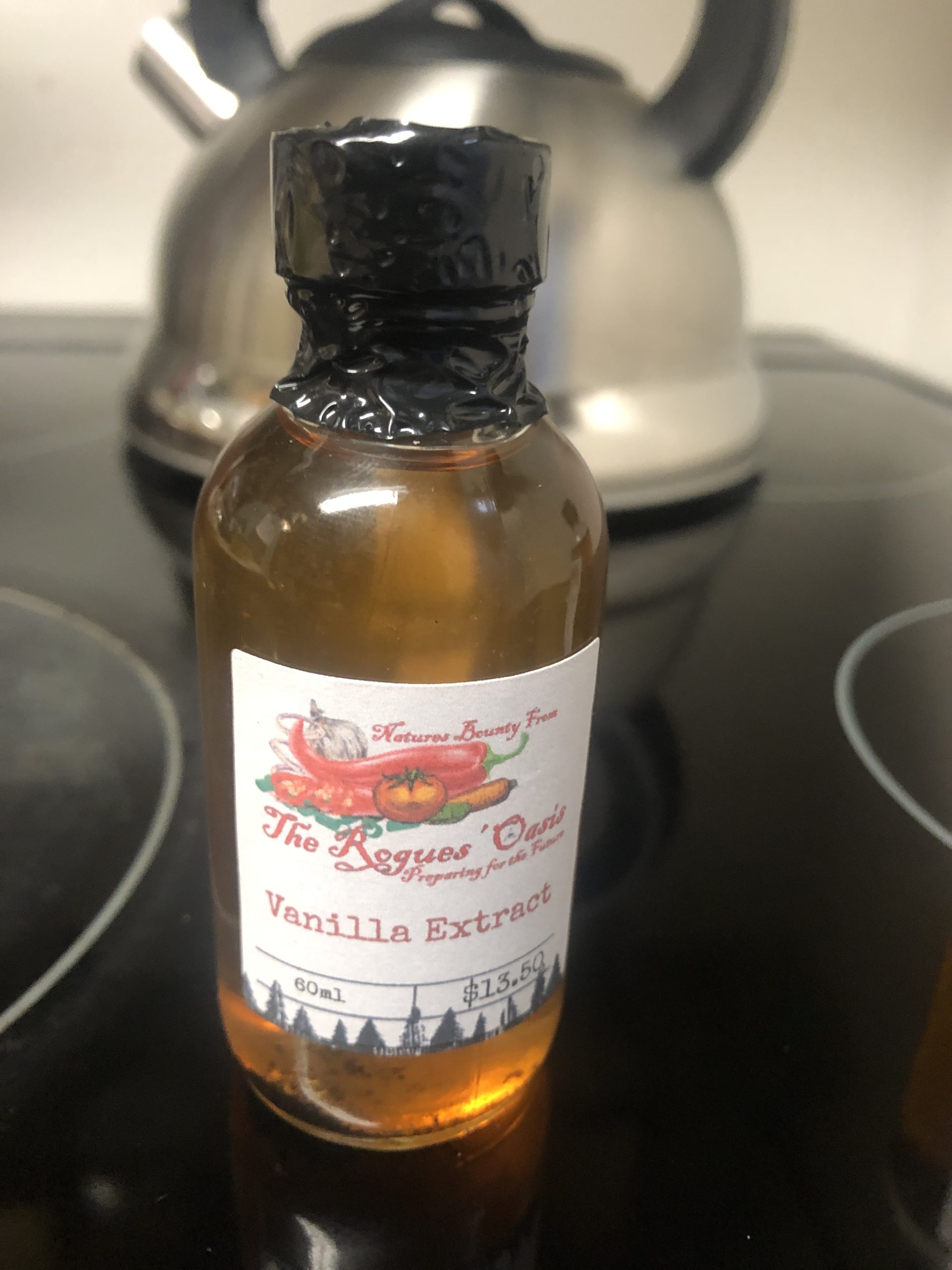 Crafted vanilla extract bottle with artisanal label by The Rogues' Oasis, emphasizing flavor and quality.