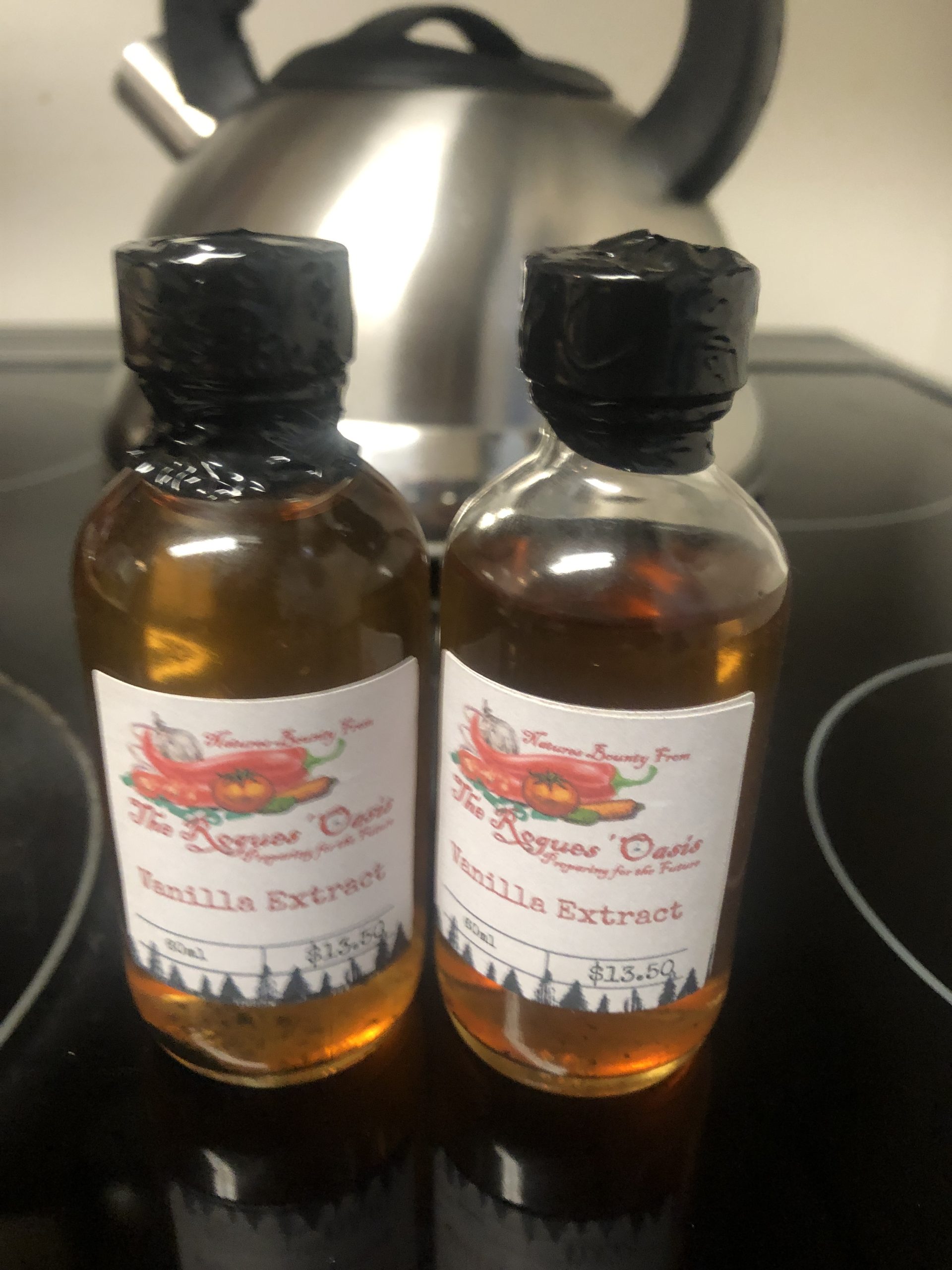 Two bottles of The Rogues' Oasis Vanilla Extract showcased on a kitchen countertop.
