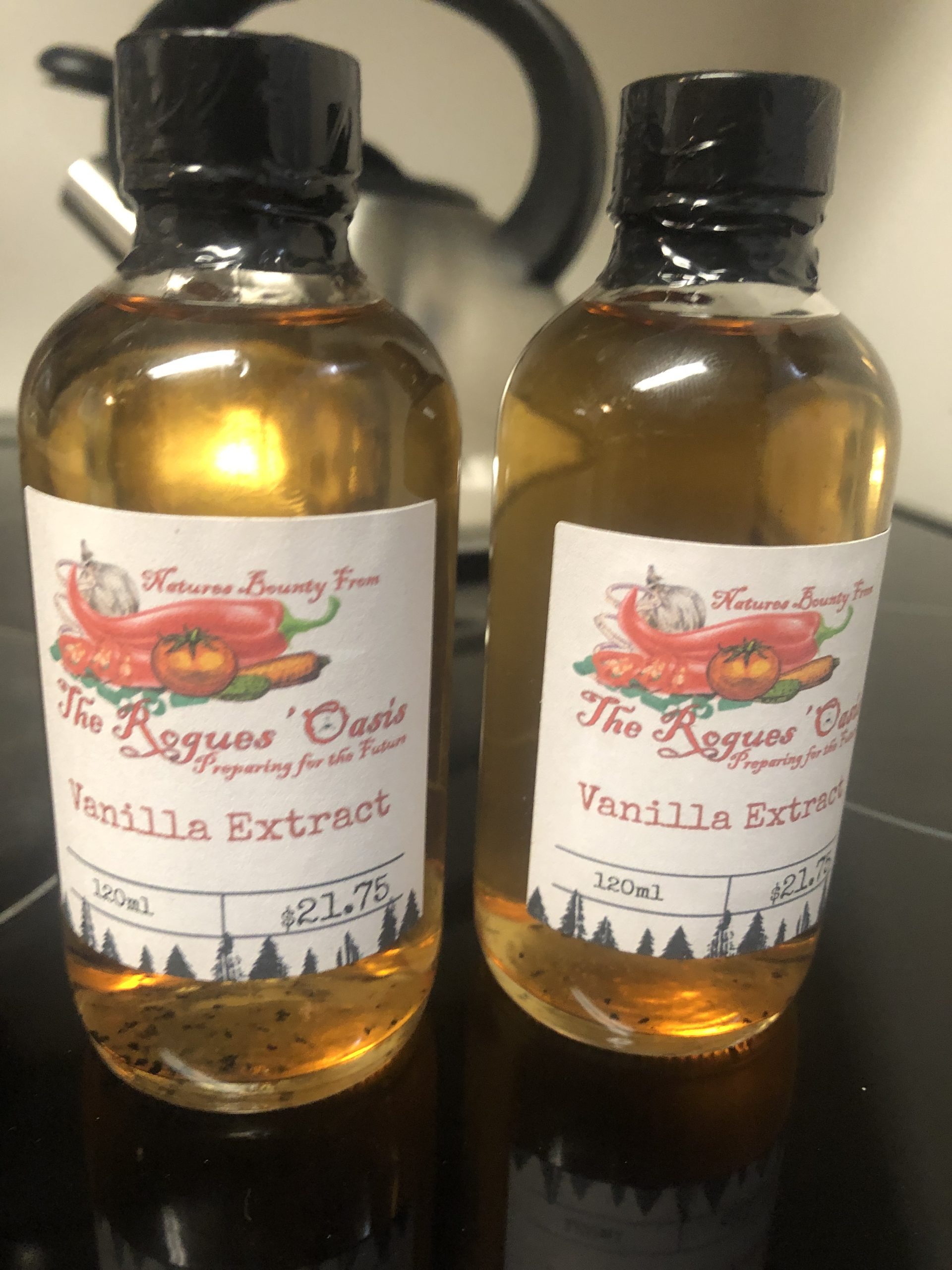 Two bottles of The Rogues' Oasis Vanilla Extract, showcasing artisanal packaging and rich essence.