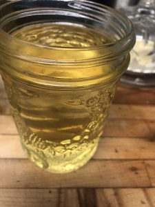 Golden rendered tallow cooling in a glass jar, exuding warmth and richness.